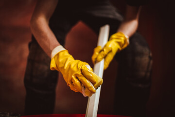 A worker washes a plastic part of a frame with a sponge.