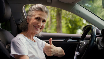 Cheerful happy Caucasian elderly mature female woman senior buyer driver car owner pensioner rental...