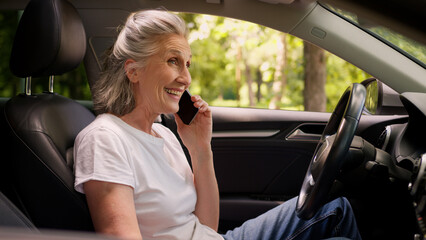 Happy smiling laughing Caucasian mature senior glad woman female pensioner auto car driver talking...