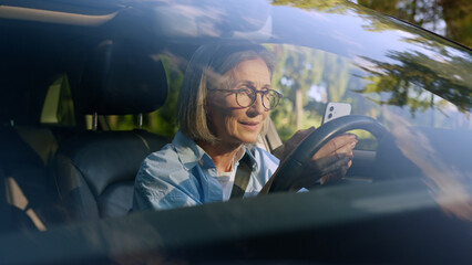 Excited shocked amazed Caucasian senior mature woman female elderly driver car owner inside...
