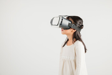 Smiling young kid girl confidence excited wear VR headset device during virtual reality experience...