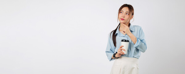Young thoughtful woman holding a cup of coffee takeaway, she thinks while holding a paper coffee,...