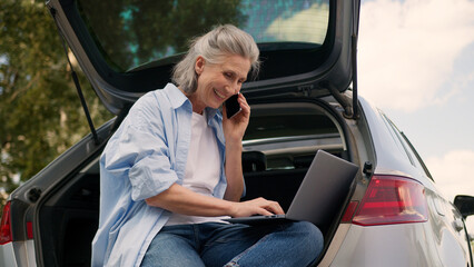 Successful Caucasian aged senior woman female older mature businesswoman browsing laptop typing...