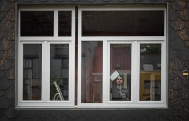 A young worker washes windows after construction work.