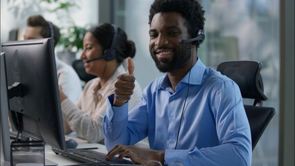 Multinational team African male callcenter operators thumbs up headset smiling office computer support female Indian coworker typing customer service happy Caucasian colleague job call center business