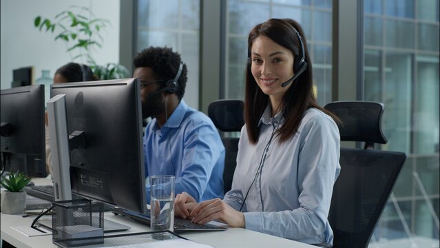 Helpline callcenter multiethnic business workers working online computer office customer service call center diverse smiling Caucasian Indian women African man in headset speak work pc helping client