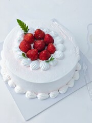Elegant Strawberry Cake Creamy White Frosting Fresh Berries and Delicate Green Leaf Garnish.