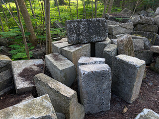 Pile of left over concrete block, concrete masonry blocks, messy arrangement, green trees surrounding
