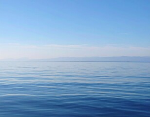 Calm, vast body of water meeting a hazy horizon