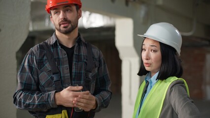 Multinational angry engineers conflict misunderstanding construction argument Asian woman Caucasian...