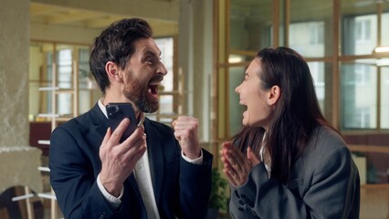 Excited two business woman man celebrating win showing mobile phone green screen chroma key mock up...