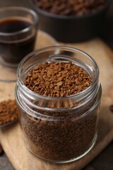 Instant coffee in glass jar, hot drink and beans on table, closeup