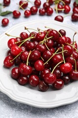 Wet ripe cherries on light table, closeup