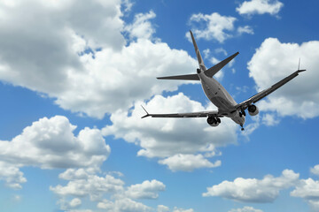 Airplane flying in beautiful blue sky with clouds