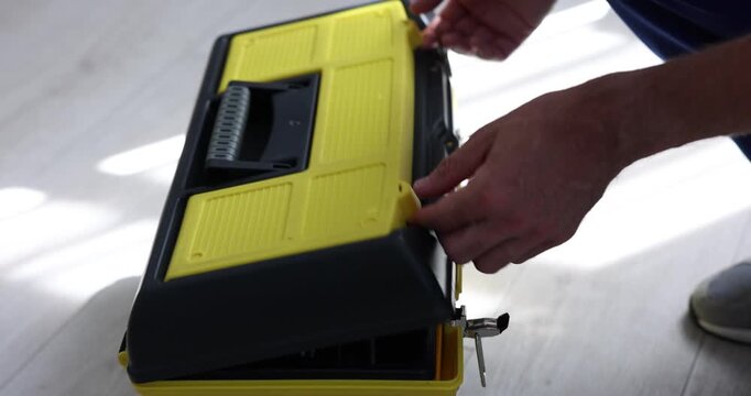 Man opening tool box and taking wrench indoors, closeup