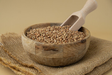 Raw buckwheat porridge in neutral beige background copy space. Whole spelt grain species. High protein fiber-rich vegan plant based food ingredient. Gluten free superfood healthy nutritional dietary