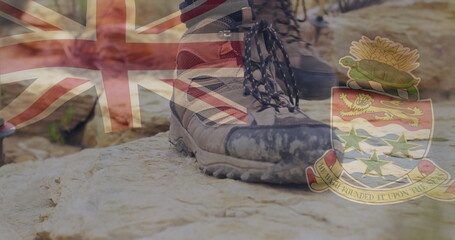 Resting hiking boots on rock, with semi-transparent Union Jack flag and Cayman Islands coat of arms