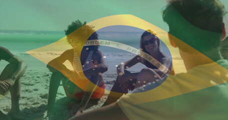 Sitting friends wearing swimwear, chatting and sipping beers on beach, with Brazilian flag overlay