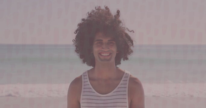 Standing man wearing striped tank top at beach shoreline, with gentle ocean waves behind - Powered by Adobe