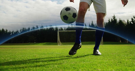 Naklejka premium Controlling soccer player lower half juggling soccer ball mid-air on grass field, with goal net
