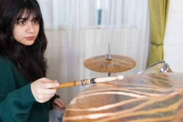 young female drummer, practicing at home