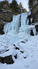 Icy waterfall cascading down snowy mountains