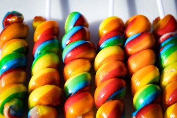 macro close-up of a rainbow candy lollipop pattern isolated on a soft white background retro party...