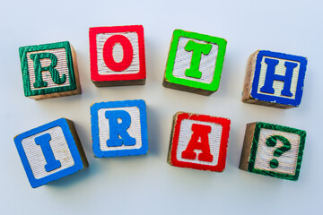 Closeup of Roth IRA building blocks design element for financial literacy concept. Retirement savings background or banner with question mark.