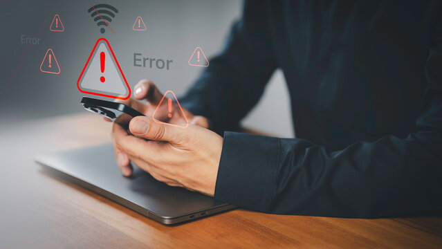 Person holding a smartphone with warning icon and a no Wi-Fi signal symbol. Idea for IT security service and digital risk content, a digital error, internet connection failure, malware, data breaches.