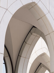 Archway of a white building with lines and shadows.