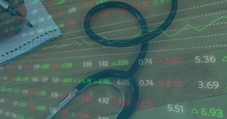 Hand nudging stethoscope and marking spiral notebook while live finance chart updating for analysis - Powered by Adobe