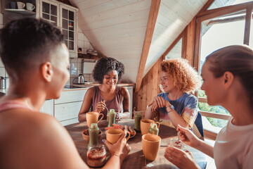 Diverse group of women enjoying healthy breakfast together in cozy cabin kitchen