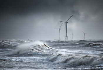 Offshore wind turbines operate in stormy sea conditions under dark, cloudy skies