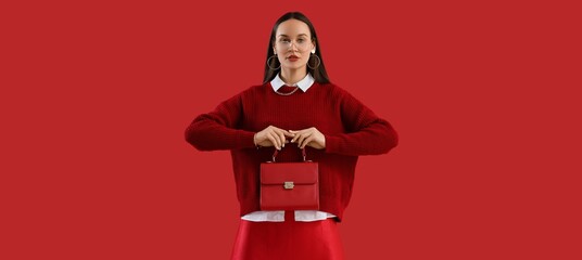 Fashionable woman with trendy bag on red background