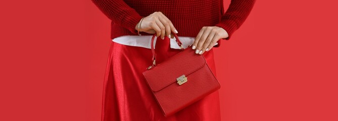 Young fashionable woman with trendy bag on red background, closeup