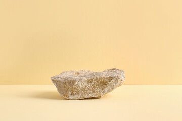 Decorative stone podium on pale orange background