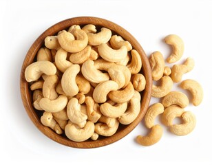Fototapeta premium Top view of Roasted cashew nuts in wooden bowl with pile of cashew nuts on white background.