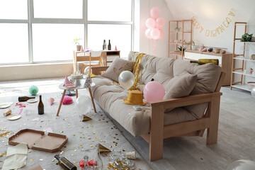 Interior of messy living room after Birthday celebration with sofa, tables and party decor