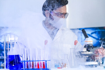 An Indian scientist in a lab coat carefully examines a sample during a pharmaceutical research and...