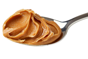 Creamy peanut butter fills silver spoon. Macro shot for culinary content, marketing, recipe ideas, blog use. Delicious dessert topping.