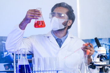 A dedicated Indian researcher analyzes a biological sample in a lab, contributing to medical...