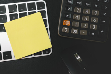 Blank Sticky Note on Keyboard and Calculator. Forecast for finances . Money, Budget, tax, investment, financial and savings.  Copy space.