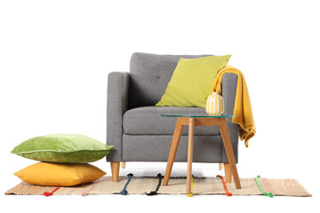 Armchair with pillows, table and carpet on white background