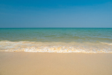 Serene tropical beach with crystal clear turquoise water, gentle waves, and a bright blue sky with fluffy white clouds. peaceful and relaxing summer scene perfect for panorama and travel concepts.