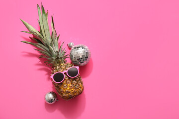 Pineapple with sunglasses and disco balls on pink background