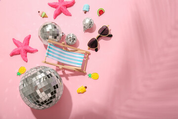 Disco balls with beach decor on pink background