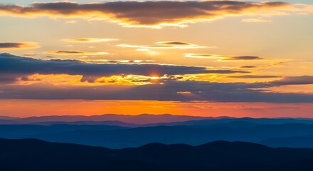 Fototapeta premium Majestic sunset over layered mountain ranges with vibrant orange and blue hues that creates