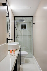 Bright Modern Bathroom with Gold‑Framed Glass Shower & Ocean‑View Balcony