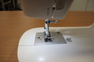 A close-up of sewing machine with needle. Clothing manufacturing and sewing. Make your own clothes with sewing machine. Sewing machine needle type.