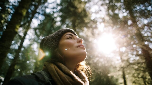 Serene woman with closed eyes, bathed in sunlight amidst a lush forest, embracing nature and wellness